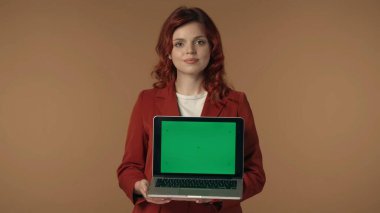 Genç bir kadının gülümseyen ve elinde reklam alanı olan bir dizüstü bilgisayarla orta ölçekli görüntüsü, çalışma alanı modeli. İş ilanı, uygulama, online kaynaklar.