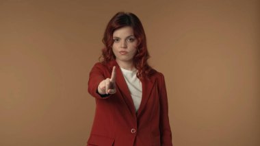 Genç bir kadının endişeli bir şekilde baktığı, sonra kamerayı işaret ettiği ve negatif bir şekilde parmağını salladığı orta ölçekli bir çekim. Şikayet ve anlaşmazlık gösteriyor. Çalışma süreci