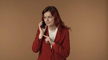 Neşeli ve aktif genç bir kadının telefonuyla konuşurken, gülerken ve gülümserken orta halli görüntüsü. Cep telefonu servisi. Yaratıcı içerik veya reklam.