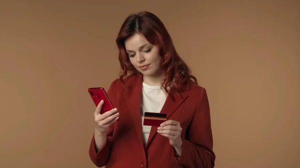 一个快乐 满意和放松的年轻女子看着手机 手里拿着信用卡 完成了网上购物 在线服务和银行业务广告 — 图库照片