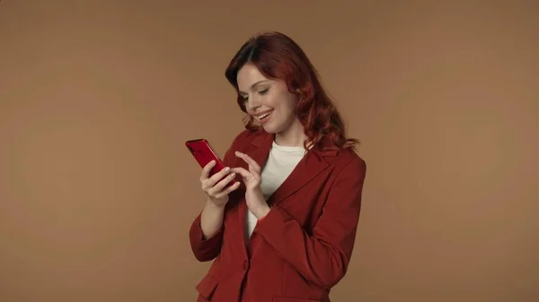 中度孤立的照片 一个年轻女人看着她的手机 发短信 或在网上买东西 女人很放松 但也很专注 促销内容 商业或广告 — 图库照片