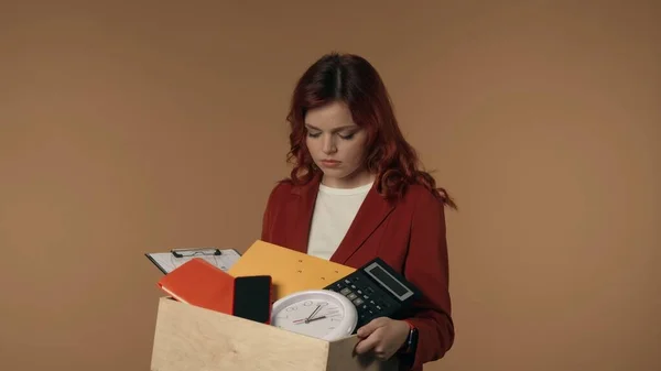一个悲伤的 泪流满面的 可怜的年轻女子从办公室拿着一个盒子 手里拿着她的东西 在被解雇后离开了画框 离职的概念 — 图库照片