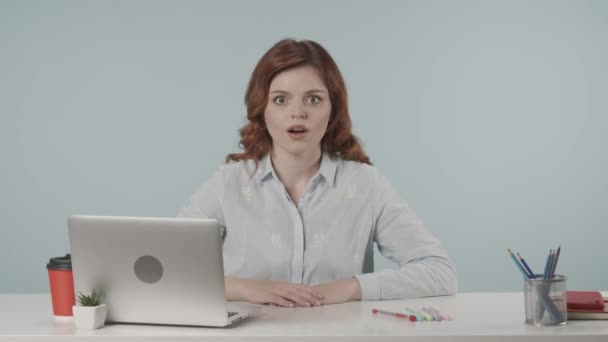 노트북과 책상에 그녀의 제스처와 놀라움을 보여주는 비즈니스 여자의 비디오 창조적인 — 비디오