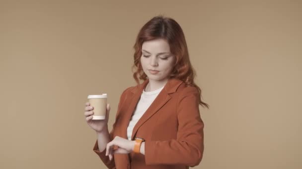 一个满意而轻松的年轻女子举着一杯咖啡 震惊地看着她的手表 喝了一口 冲出了镜框 这段视频是一段中等隔离的视频 时间管理概念 Hdr — 图库视频影像
