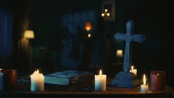 视频记录了一张桌子 上面有神奇的工具 十字架和一本书 女性人物手拿着烛台慢慢地进入画框 神秘的仪式和仪式 万圣节主题 — 图库视频影像