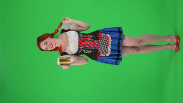 フルサイズの垂直緑色のスクリーンは 若いドイツ人女性 ウェイトレスのクロマキービデオを分離し ラガー ビール フラット 彼女のブレードを回転させました 10月フェスト ビールフェスティバル — ストック動画