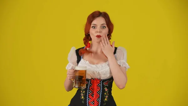 一个年轻的德国女人 穿着传统服装 手里拿着一杯啤酒 脸上洋溢着兴奋的表情 10月节 — 图库照片