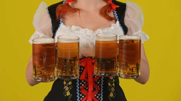 特写黄色背景孤立的照片一个无法辨认的年轻德国女人 女服务员穿着传统服装 拿着四杯啤酒 十月节 — 图库照片