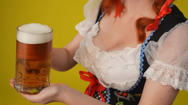 近距离的黄色背景孤立地拍摄了一个无法辨认的年轻德国女人 穿着传统服装的女服务员 提供了一杯啤酒 十月节 乳房节 — 图库照片