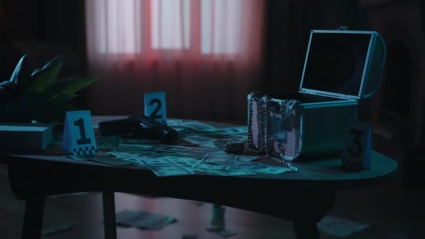 犯罪现场创意的概念 黑漆漆的公寓里的桌子上有抢劫的痕迹 手枪和装有珠宝的开箱 桌上有证件号码 — 图库视频影像