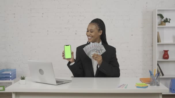 现代女商人的概念 办公室里年轻非洲裔美国女性的画像 女人手里拿着智能手机和粉丝的钞票 广告区 工作空间模型 Hdr Bt2020 Hlg — 图库视频影像