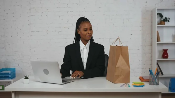 现代女商人的创意概念 办公室里年轻非洲裔美国女性的画像 女人坐在办公桌前工作 看着桌子上的纸袋 面带微笑 — 图库照片