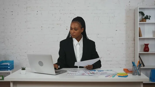 现代女商人的创意概念 办公室里年轻非洲裔美国女性的画像 妇女坐在办公桌前 拿着文件在笔记本电脑上工作 阅读文件 — 图库照片