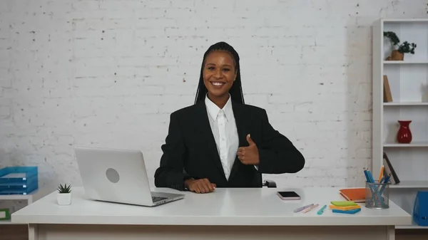 现代女商人的概念 办公室里年轻非洲裔美国女性的画像 女人坐在办公桌前 看着摄像机 大拇指翘起 喜形于色 — 图库照片