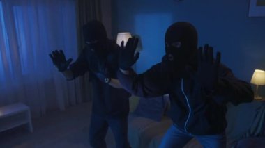 Evde suçüstü yakalanan iki hırsızın videosu var. Polis onlara silah doğrultuyor. Adamlar yere yatsın, maskeleri çıkarsınlar. Güvenlik, güvenlik ya da güvenlik ajansı, reklam.