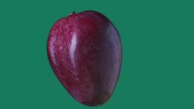 Sağlıklı gıda reklamları yaratıcı konsept. Yeşil arka planda izole edilmiş. Meyveler ekrana karşı dönüyor. Mango dönüşünün yakın plan çekimi tüm açılarla askıya alındı. Krom anahtar.