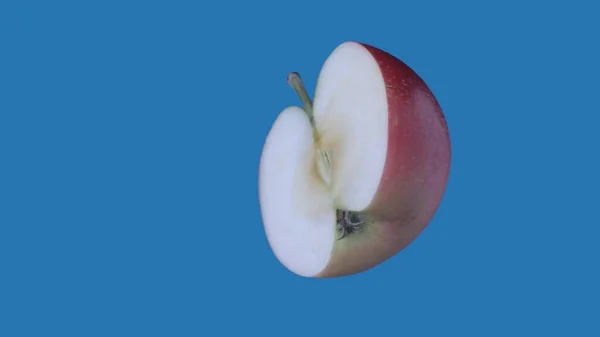 果物や野菜を健康的に食べるクリエイティブなコンセプト 着色されたスクリーンに対するフルーツ 青い背景に隔離された傾斜したりんごのクローズアップスタジオショット — ストック写真