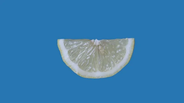 果物や野菜を健康的に食べるクリエイティブなコンセプト 着色されたスクリーンに対するフルーツ ブルーの背景に隔離されたレモンの半分のスライスのクローズアップスタジオショット — ストック写真