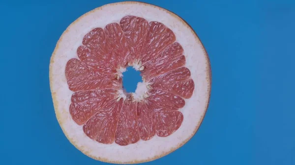 果物や野菜を健康的に食べるクリエイティブなコンセプト 着色されたスクリーンに対するフルーツ ブルーの背景に隔離された熟したグレープフルーツスライスのクローズアップスタジオショット — ストック写真