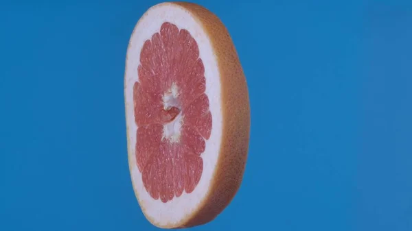 果物や野菜を健康的に食べるクリエイティブなコンセプト 着色されたスクリーンに対するフルーツ ブルーの背景に隔離された熟したグレープフルーツのスライス側のビューのクローズアップスタジオショット — ストック写真