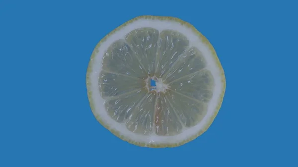 果物や野菜を健康的に食べるクリエイティブなコンセプト 着色されたスクリーンに対するフルーツ ブルーの背景に隔離されたレモンの丸いスライスのクローズアップスタジオショット — ストック写真