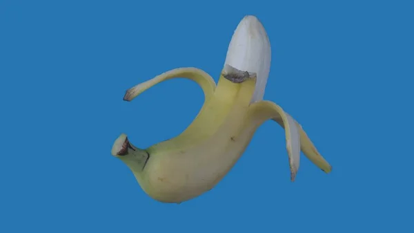 果物や野菜を健康的に食べるクリエイティブなコンセプト 着色されたスクリーンに対するフルーツ 青い背景に隔離された半分開いたバナナのクローズアップスタジオショット — ストック写真