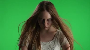 Orta yeşil ekran, ele geçirilmiş bir kadın, kadın figürü, hayalet, kötü ruh, ellerini kameraya çeken zombi, homurdanan, sırıtan bir kadının krom anahtar videosu. Korku klibi, reklam, yürüyen ölü.