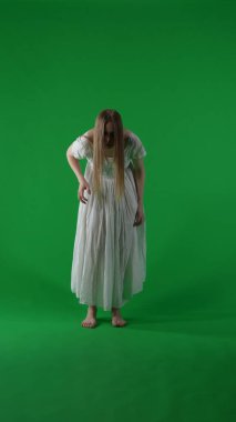 Tam boy dikey yeşil ekran, ele geçirilmiş bir kadın figürü, kadın figürü, hayalet, kötü ruh, ani ve sarsıcı bir şekilde hareket eden zombi görüntüsü. Korku klibi, reklam, yürüyen ölü..