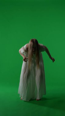Tam boy dikey yeşil ekran, ele geçirilmiş bir kadın figürü, kadın figürü, hayalet, kötü ruh, ani ve sarsıcı bir şekilde hareket eden zombi görüntüsü. Korku klibi, reklam, yürüyen ölü..