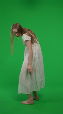 Tam boy yarım ekran dikey yeşil ekran, ele geçirilmiş bir kadın, kadın figürü, hayalet, kötü ruh, yüzünü kameraya çeviren zombi görüntüsü. Korku klibi, reklam, yürüyen ölü..