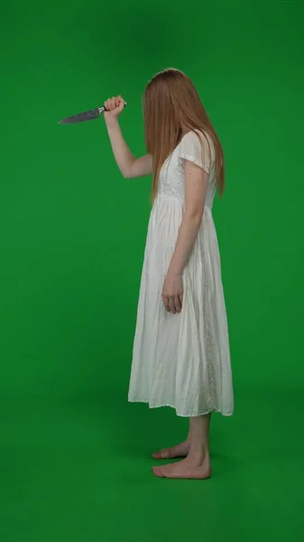 フルサイズのサイドビュー垂直緑色のスクリーン クロマキーショット ポーズの女性 女性図 ポルテジスト ゾンビは ナイフを引き出す ホラークリップ ウォーキングデッド — ストック写真