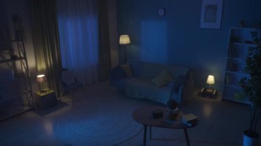 Hala bir dairenin videosu, gece yarısı bir daire. Boğuk, hafif, rahat bir oda. Koltuk, kanepe, masa ve odadaki diğer mobilyalar. Gece yarısından sonra. Yaratıcı içerik, reklam. HDR