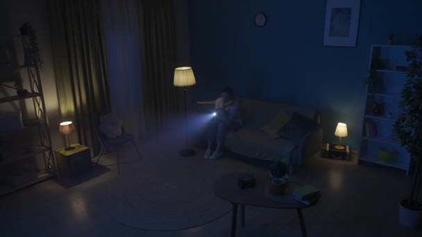 Video Una Joven Sentada Sofá Una Habitación Oscura Buscando Intrusos — Vídeos de Stock