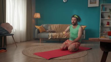 Bir odada orta yaşlı bir adam yorgunluktan bitkin düşene kadar spor paspası üzerinde yerden şınav çekiyor ve sonra da yere düşüyor. Evde fitness var. Sağlıklı yaşam tarzı kavramı. Vücut pozitifi