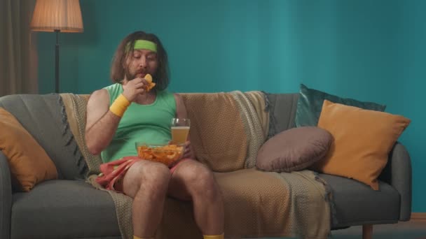 Seorang Pria Paruh Baya Gemuk Duduk Sofa Sebuah Ruangan Dengan — Stok Video