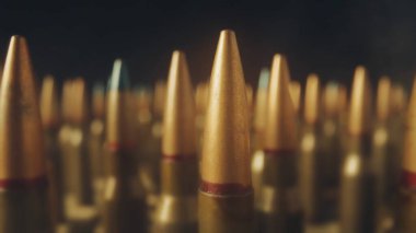 Siyah arka plandaki bir tüfek için bitmek bilmeyen fişekler. Odaklanmamış arka plan. Ateşli silahlar, atış menzili, üretim ve mühimmat ticareti kavramı