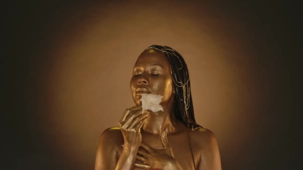 Nasieniowłosa Afroamerykanka Złotą Skórą Dotyka Się Pączkiem Białego Gladiolusa Kobieta — Wideo stockowe