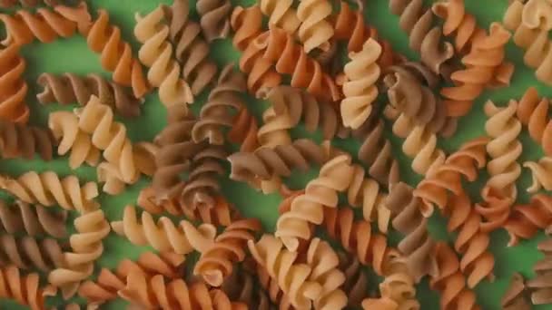 Gros Plan Nombreuses Spirales Pâtes Colorées Sur Fond Vert Remplissant — Video