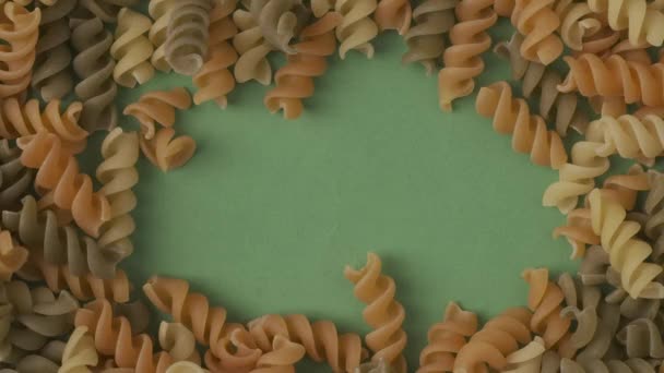 Gros Plan Nombreuses Spirales Pâtes Colorées Sur Fond Vert Espace — Video