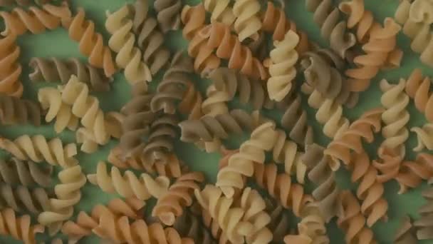 Gros Plan Nombreuses Spirales Pâtes Colorées Sur Fond Vert Remplissant — Video