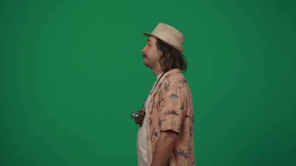 旅行広告クリエイティブコンセプト カジュアルな服を着て 古いフィルムカメラで帽子をかぶった男は ハッピーな顔でカメラに向かい 空中に拳をポンピングします 緑の背景に孤立した — ストック動画