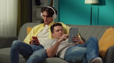 Evde homoseksüel bir çiftin videosu. Kanepede yatıyorlar, internette kayıyorlar. Biri, sevdiği bir şarkıyı paylaşması için ortağına kulaklıklarını vermek. LGBT, eşitlik, eğitim içeriği