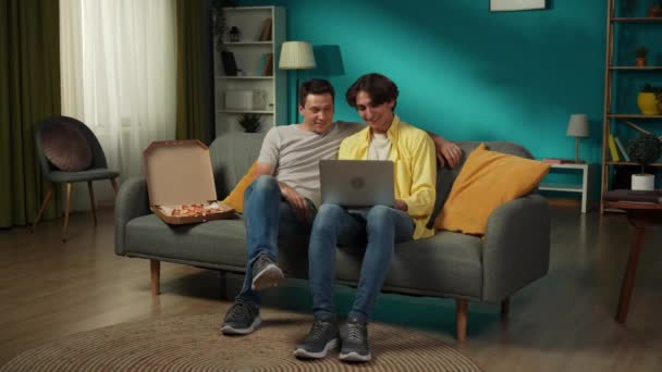 집에서 동성애 커플의 사이즈 비디오 그들은 소파에 앉아서 노트북으로 사진을 — 비디오