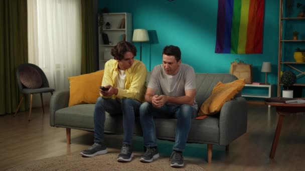 Полноразмерное Видео Гомосексуальной Пары Сидящей Диване Вдруг Один Выражает Стресс — стоковое видео