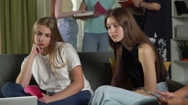 10代の若者 試験の準備 話し合い ノートを見ながらソファに座っている男の子と2人の女の子のミディアムビデオ — ストック動画