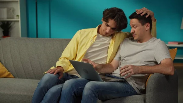 Shot Homosexual Couple Home One Sitting Couch Working Laptop Explaining — Stock Photo, Image