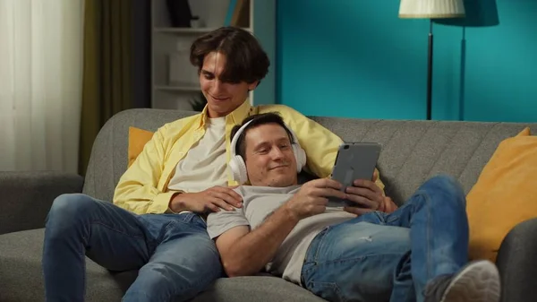 Evde Homoseksüel Bir Çiftin Fotoğrafı Kanepede Uzanmış Tablette Fotoğraf Video — Stok fotoğraf