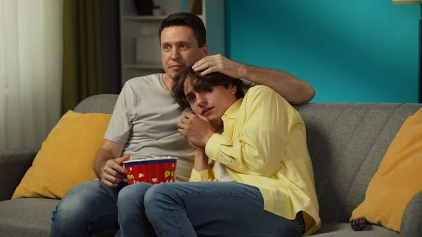 ソファーに座り 一緒にテレビを見たり ポップコーンを食べたりする同性カップルのショット 彼らの1人はホラー映画を恐れ パートナーは彼らを慰めようとします Lgbt プライド — ストック写真