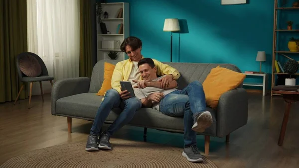 一对同性恋夫妇在家里拍的全景照片他们躺在沙发上 看着平板电脑上的照片或视频 彼此表达爱意 Lgbt — 图库照片