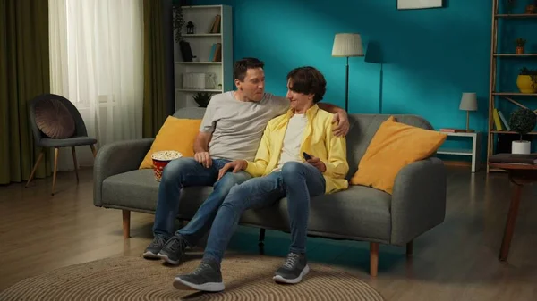 一对同性恋夫妇在家里拍的全景照片他们坐在沙发上 一起看电视 吃爆米花 彼此表达爱意 Lgbt — 图库照片